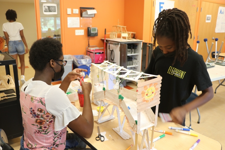 Students in the Summer STEM program build bridges out of popsicle sticks. 